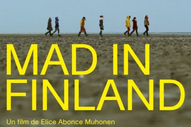 Mad in Finland dokumenttielokuvan juliste. Elokuvan 7 esiintyjää kävelee peräkkäin tyhjällä rannalla sadevaatteet päällä.  Mad in Finland teksti keltaisena kuvan päällä.