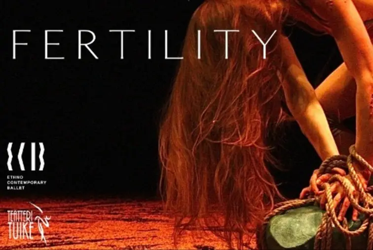Fertility-tanssiteoksen mainoskuva, jossa tanssija kumartuu köysiin kietoutuneen vihreän kiven ylle lämpimässä punaisessa valaistuksessa. Kuvassa lukee FERTILITY ja Teatteri Tuike.