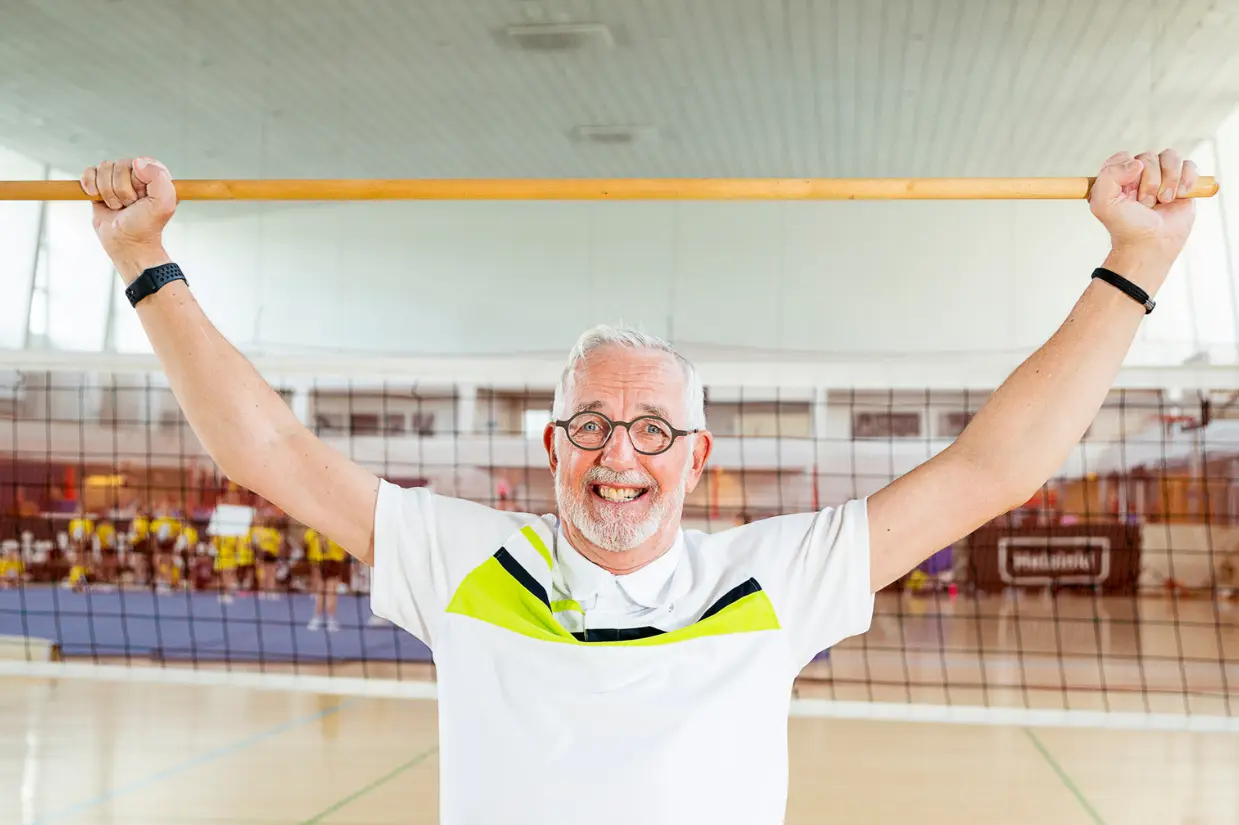 hymyilevä mies on nostanut jumppakepin pään päälle