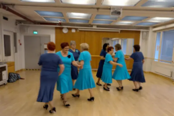 Naiset tanssivat sinisissä mekoissa