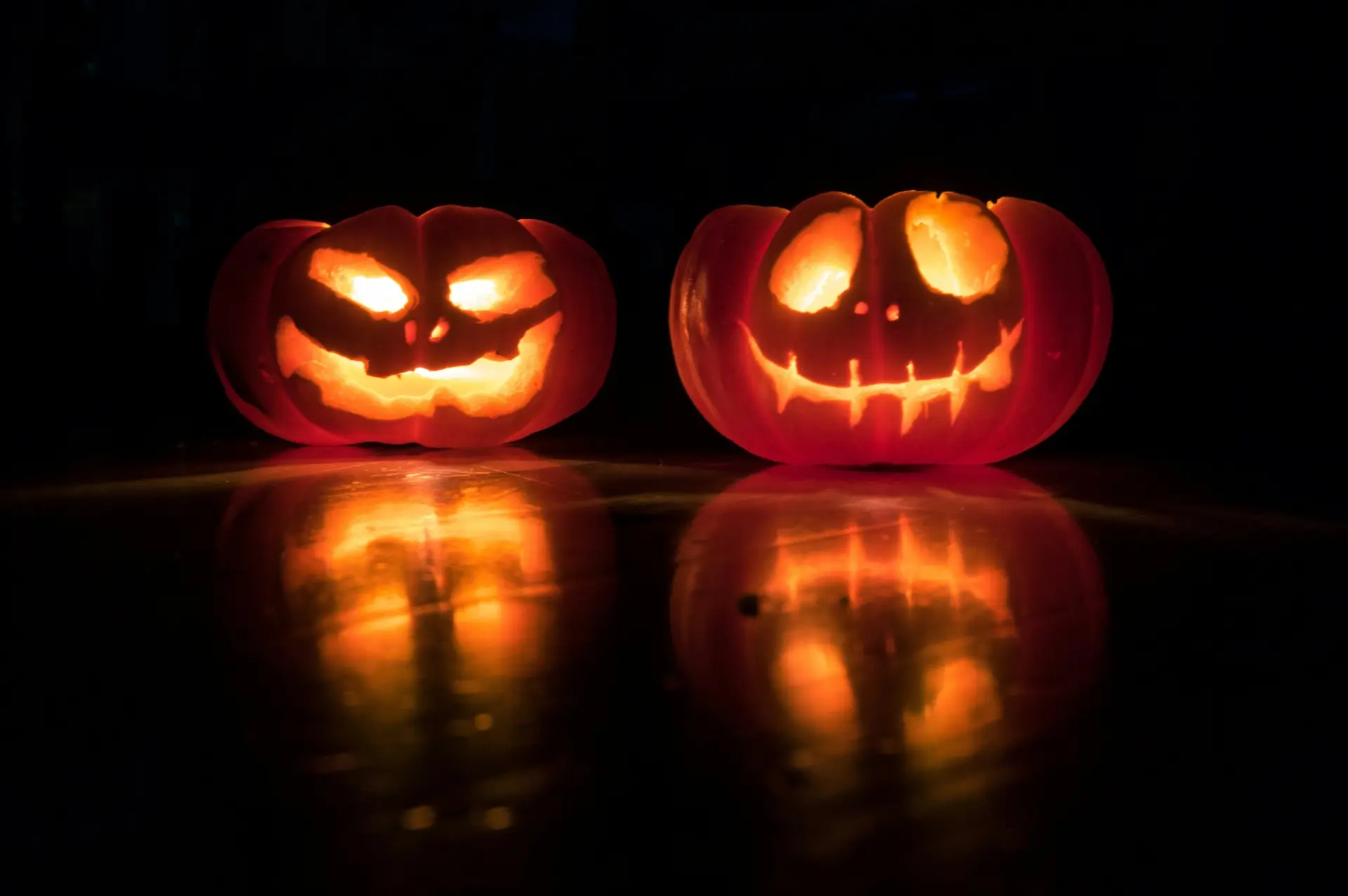 pimeässä loistaa kaksi kurpitsaa johon on kaiverrettu halloween naamat