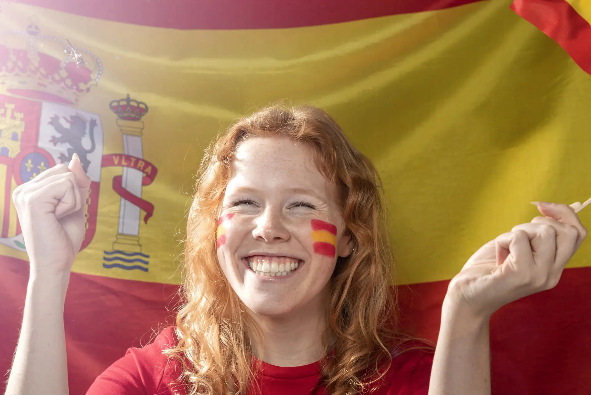 Nainen hymyilee Espanjan lippu taustalla